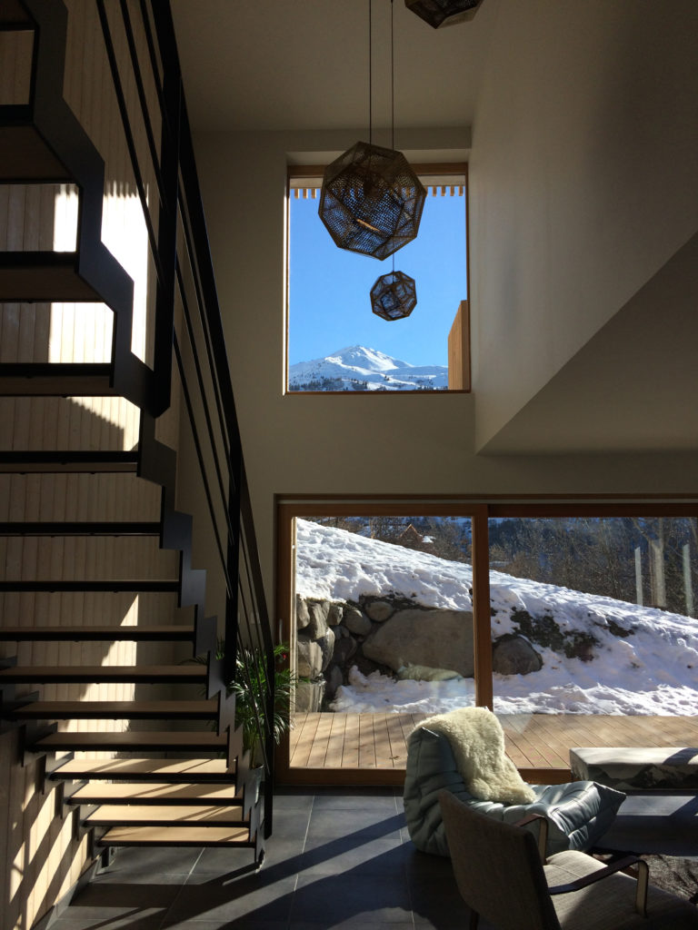 Gîte des Mille Thabor à Valmeinier : vue sur la partie du gîte et son bardage mélèze avec la station Galibier-Thabor en arrière-plan.