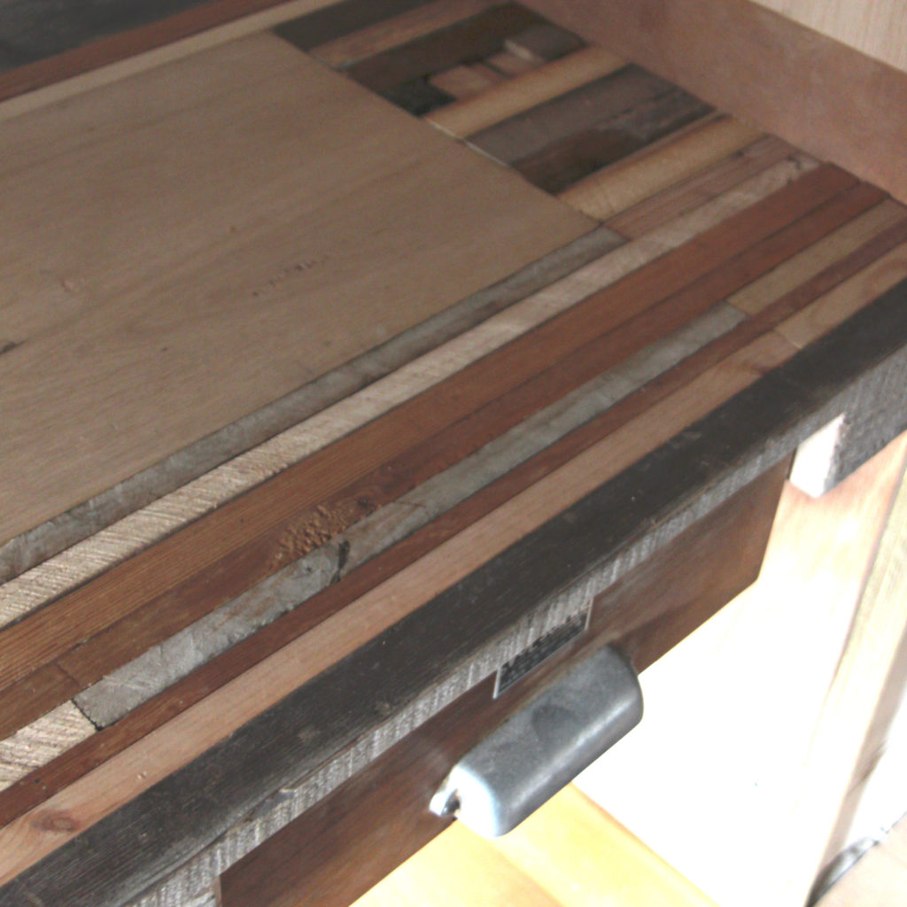 Bureau en bois récupéré et valorisé : bureau en planches sur champs contre-clouées alternées entre elles suivant leurs teintes et leurs veines.